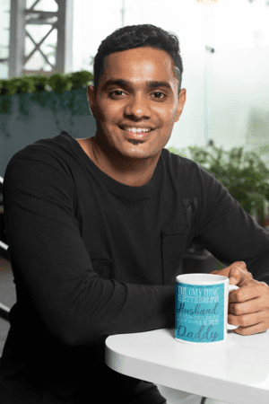 11-oz-coffee-mug-mockup-featuring-a-joyful-man-sitting-at-a-white-table-28965-1