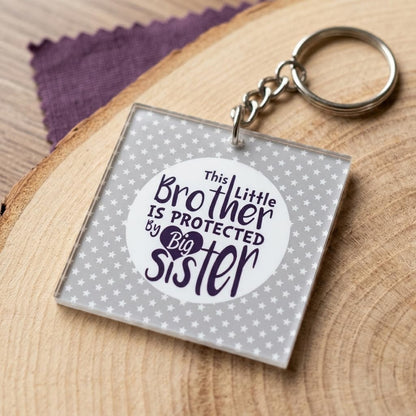 TheYaYaCafe Keychain Gift for Younger Brother, Little Brother Protected by Big Sister Printed Keyring, Birthday Rakhi Raksha Bandhan Gift for Brother, Bro, Bhai from Sister, Durable Acrylic Keychain
