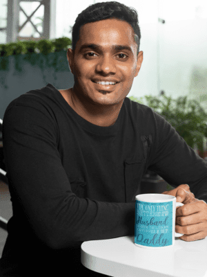 11-oz-coffee-mug-mockup-featuring-a-joyful-man-sitting-at-a-white-table-28965-1