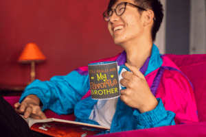 11-oz-colored-rim-mug-mockup-featuring-a-joyful-man-reading-on-a-couch-27823-3-1-1